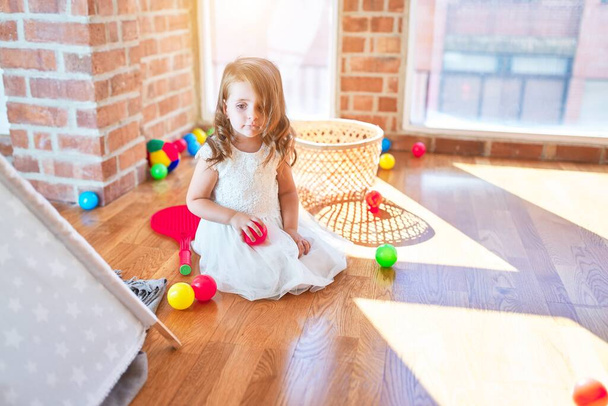 Sevimli sarışın çocuk anaokulunda bir sürü oyuncakla oynuyor. - Fotoğraf, Görsel