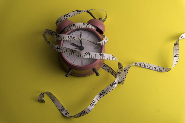 Horloge avec ruban à mesurer, régime alimentaire ou concept de saine alimentation
.  - Photo, image