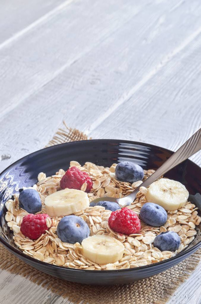 Healthy sweet breakfast. Oatmeal with blueberries, raspberries and bananas. - 写真・画像