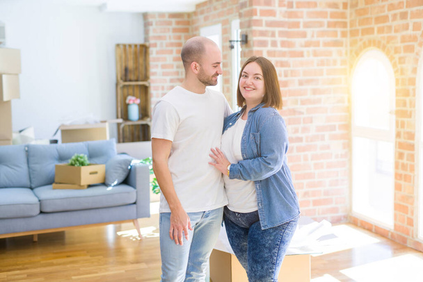 Giovane coppia insieme sorridente felice trasferirsi in una nuova casa
 - Foto, immagini