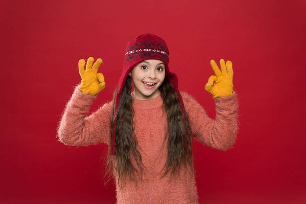 Excellent weather. Winter outfit. Cute model enjoy winter style. Little kid wear knitted hat. Stay warm. Little girl winter fashion accessory. Small child long hair wear hat burgundy background - Fotó, kép