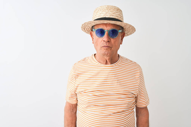 Старший чоловік у смугастих футболкових сонцезахисних окулярах та капелюсі сумера над ізольованим білим тлом з впевненим виразом на розумному обличчі, думаючи серйозно
 - Фото, зображення
