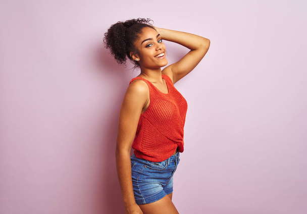 カジュアルなオレンジのTシャツを着て立っている若い美しいアフリカ系アメリカ人女性 - 写真・画像