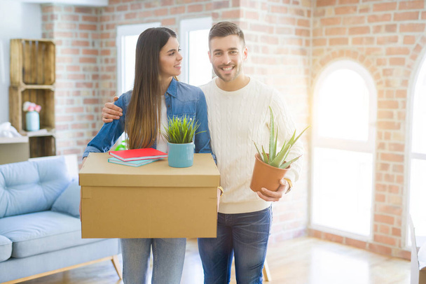 Beautiful young couple moving to a new house, smiling happy hold - Foto, Bild