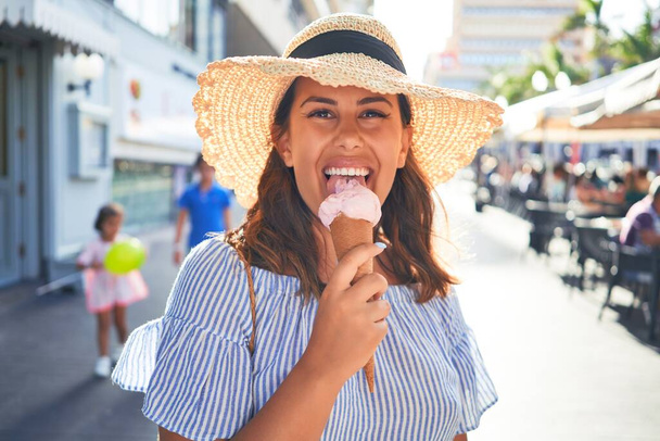 Молодая красивая женщина ест мороженое рожок прогуливаясь по улице Тенерифе в солнечный день лета на каникулах
 - Фото, изображение
