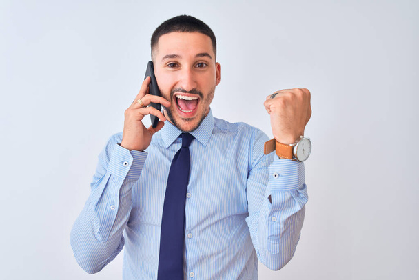 Young handsome business man calling using smartphone over isolated background screaming proud and celebrating victory and success very excited, cheering emotion - Foto, Bild