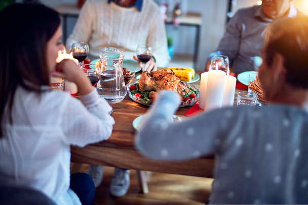 伝統的な料理と装飾でクリスマスの前夜を祝う家で家族や友人の食事、すべて一緒にテーブルの上に座って - 写真・画像