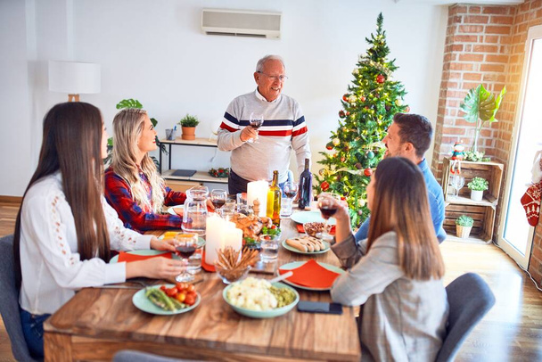 Beautiful family meeting smiling happy and confident. Speaking speech eating roasted turkey celebrating Christmas at home - Foto, Bild