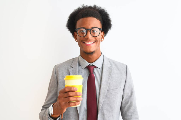 Afrykański amerykański biznesmen pijący kawę na odizolowanym białym tle ze szczęśliwą twarzą stojącą i uśmiechniętą z pewnym uśmiechem pokazującym zęby - Zdjęcie, obraz