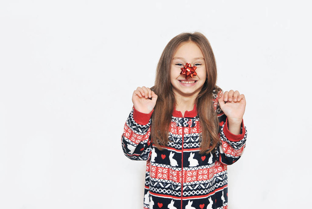 Cute girl in pajama with bow on white background. - Photo, Image
