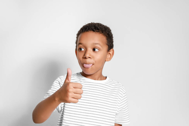 Grimacing African-American boy showing thumb-up gesture on white background - Foto, immagini