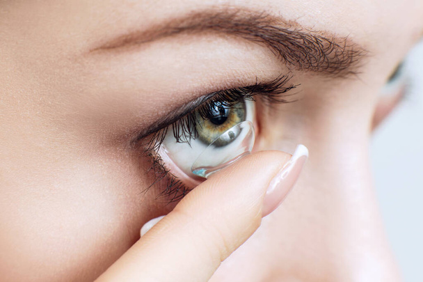 Close-up shot of young woman wearing contact lens. - Fotoğraf, Görsel