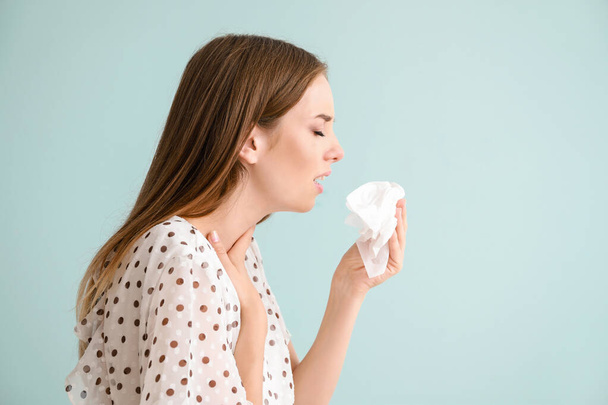 Mujer joven que sufre de alergia en un fondo claro
 - Foto, imagen
