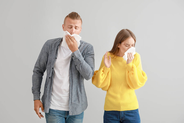 Young couple suffering from allergy on light background - Photo, Image