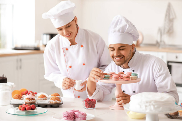 Young confectioners cooking tasty dessert in kitchen - Photo, Image