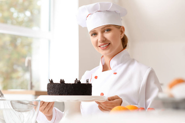 Konditorin mit leckerem Kuchen in der Küche - Foto, Bild