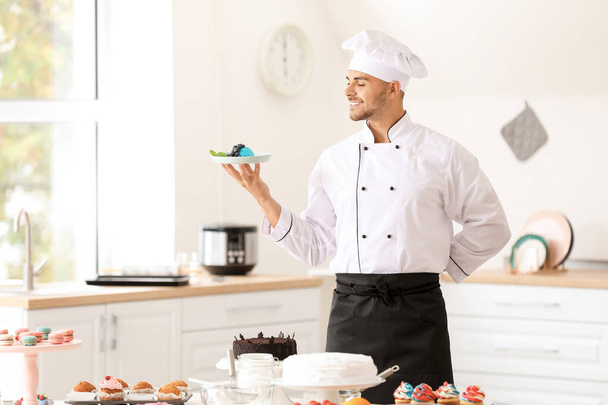 mężczyzna cukiernik z smaczny deser w kuchni - Zdjęcie, obraz