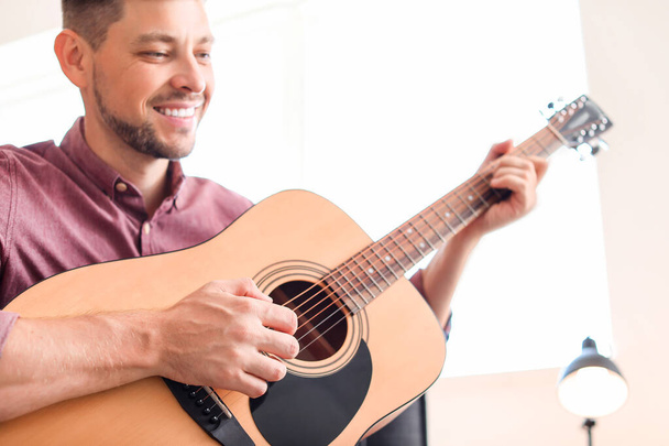 Handsome man playing guitar at home - Foto, Imagen