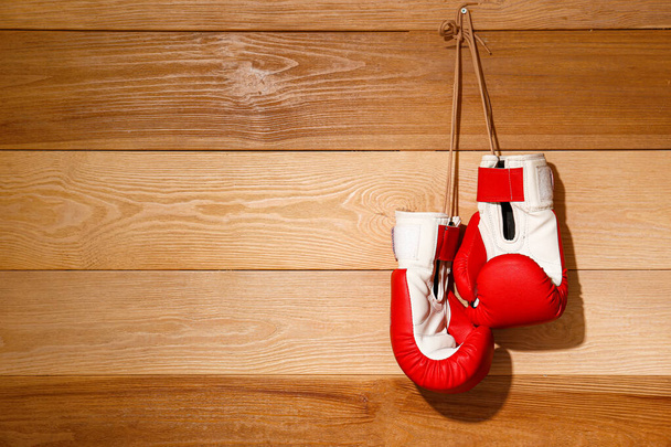 Пара боксерских перчаток, висящих на деревянной стене
 - Фото, изображение