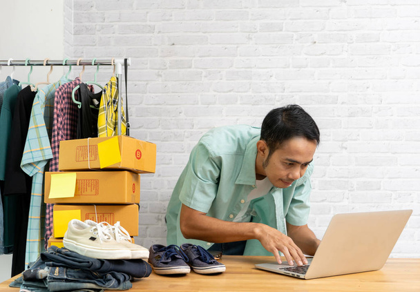 Asian man working laptop computer selling online - Foto, afbeelding