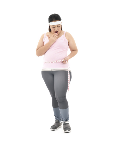 Sobrepeso mujer asiática midiendo su cintura grasa vientre aislado sobre fondo blanco
 - Foto, imagen