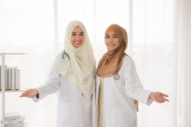Portrait de deux musulmanes médecin debout au bureau
 - Photo, image