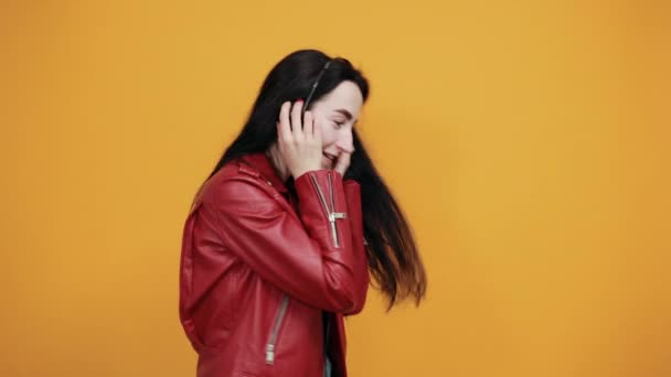 Smiling young woman listen music putting hands on headphones - Metraje, vídeo