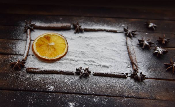 Bodegón de Navidad de naranjas secas, canela, anís estrellado azúcar en polvo
 - Foto, Imagen