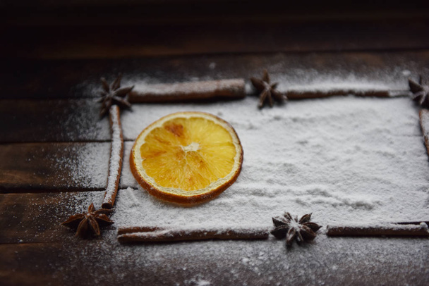 Christmas still life of dried oranges, cinnamon, star anise powdered sugar - Photo, Image