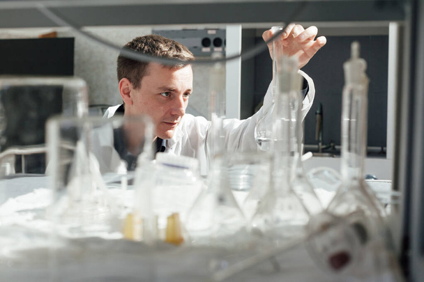 男性科学者は医学研究所で化学実験を行い - 写真・画像