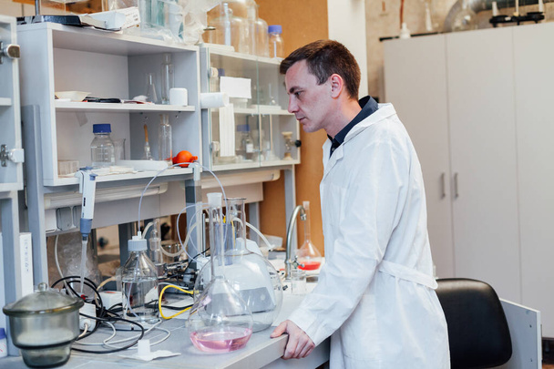 mannelijke wetenschapper voert chemische experimenten uit in medisch wetenschappelijk laboratorium - Foto, afbeelding