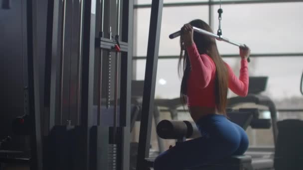 Női diák rázza őt vissza egy edzés az edzőteremben. Képzés a csarnokban nagy ablakokkal - Felvétel, videó