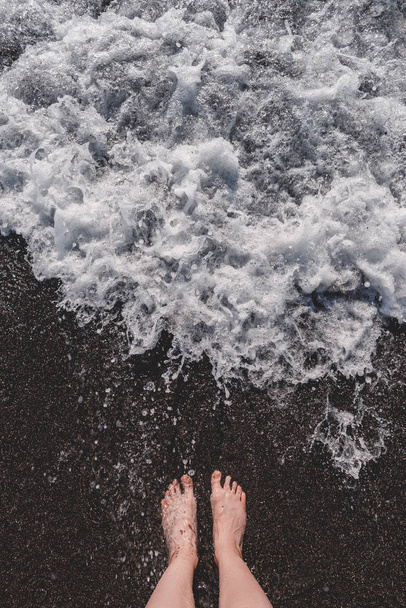 Feet in the sand. Shore and sea waves. - Φωτογραφία, εικόνα