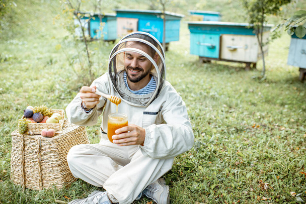 Apicultor com mel no apiário
 - Foto, Imagem