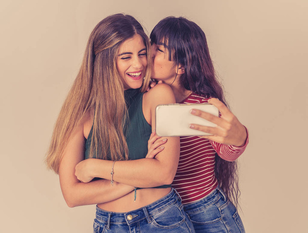 Two beautiful happy girlfriends taking selfies or recording video for blog on social media. Selfie of two beautiful women together having fun. People, technology, friendship and social media concept. - Fotoğraf, Görsel