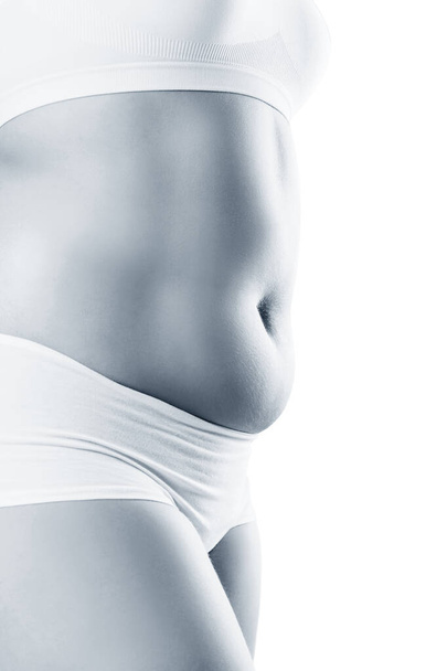 Vista lateral de mujer con vientre gordo. Concepto de obesidad
. - Foto, Imagen