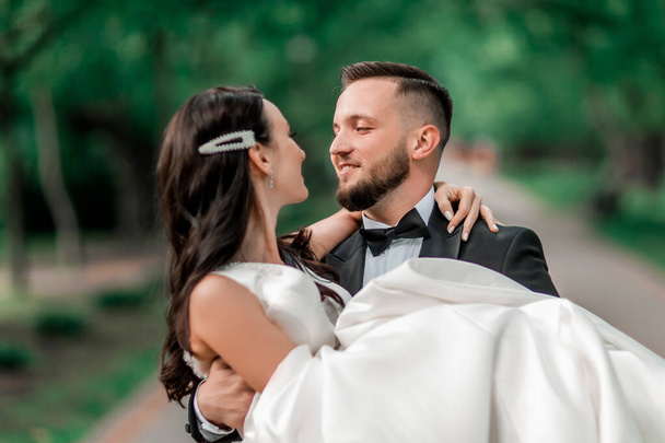 happy groom carries the bride in his arms - Foto, immagini