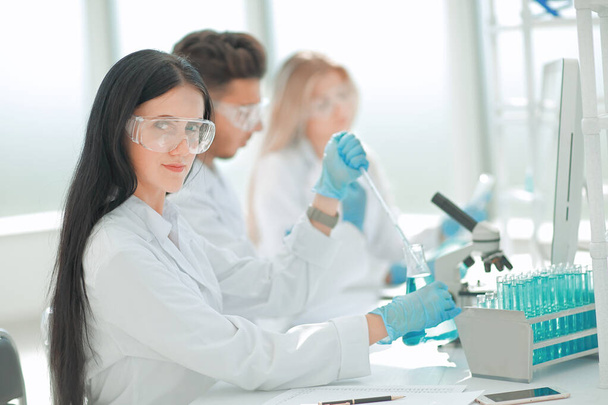 close up.modern woman sitting with colleagues at the laboratory table. - Foto, afbeelding