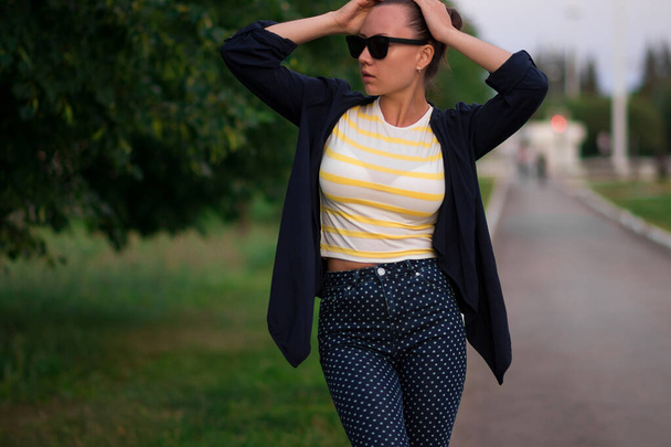 Sebevědomý fit mladá žena v sluneční brýle na chodníku v parku - Fotografie, Obrázek