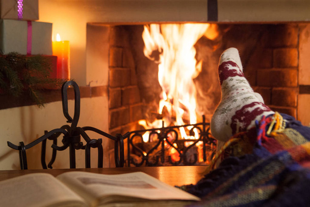 Man and woman in warm socks near the fireplace. Cup with a hot drink. Heart. - Foto, immagini