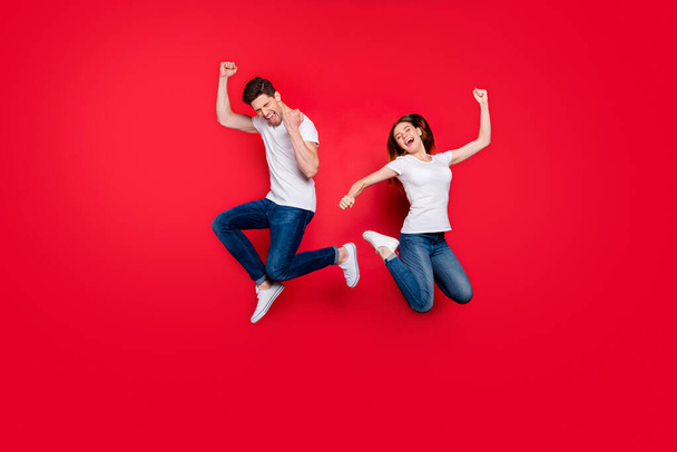 Full length body size photo of cheerful positive excited ecstatic overjoyed girlfriend wearing jeans denim white t-shirt footwear screaming yes yeah jumping isolated vivid color background - Photo, Image