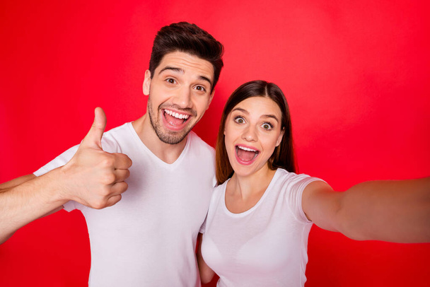Photo of cheerful redhair nice pretty charming couple of girlfriend boyfriend smiling toothily showing in white t-shirt thumb up with excitement on face isolated vivid color background - Foto, Bild