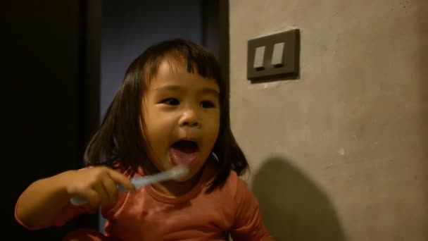 Adorabile ragazza asiatica bambino lavarsi i denti di fronte a uno specchio al mattino. Concetto sanitario
. - Filmati, video