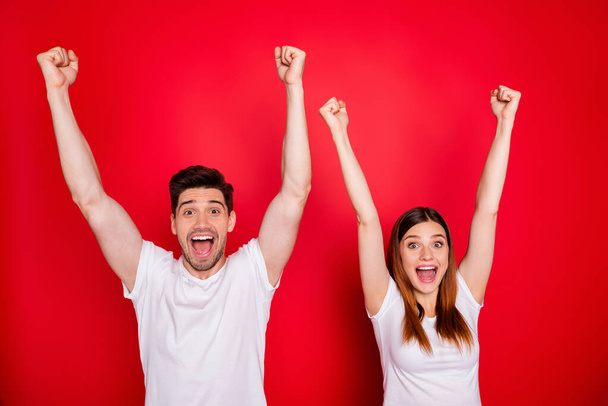 Photo of cheerful excited students couple of two people expressing emotions on face in white t-shirt screaming yeah raising hand up boyfriend girlfriend happy together isolated bright color background - Фото, зображення