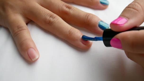 Primo piano di mani femminili pittura smalto blu, manicure fatta da sé a casa
. - Filmati, video