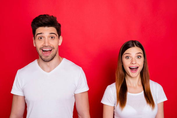 Photo of cheerful excited white t-shirt cute pretty sweet couple of spouses excited about discount at shopping center with emotions on faces isolated vivid color background - 写真・画像
