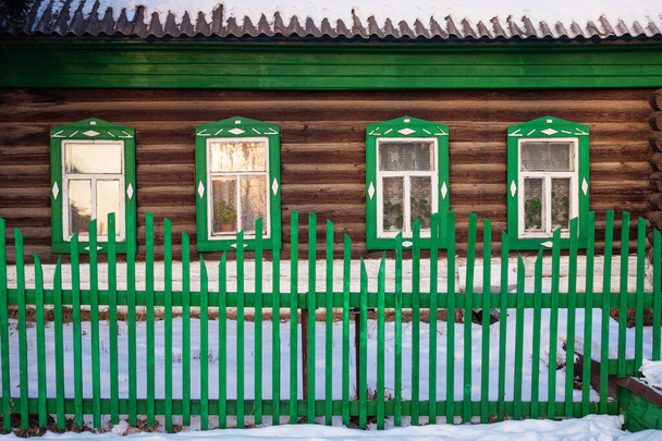 Вид спереду на зелений дерев'яний фасад кабіни взимку
. - Фото, зображення