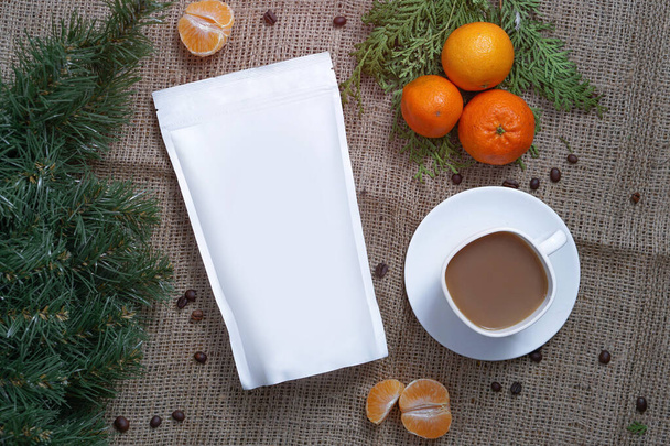 Malli paperi ekologinen laukku säilyttää kahvia, teetä taustalla rakenne ja kuppi cappuccino mandariinit. Tyhjiö pakkaus jouluksi ja uusi vuosi läsnä
 - Valokuva, kuva