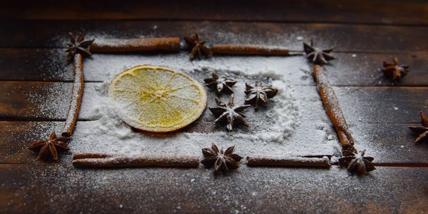 frame van sinaasappelkaneelstokjes steranijs suikerpoeder voor kerstdecor - Foto, afbeelding
