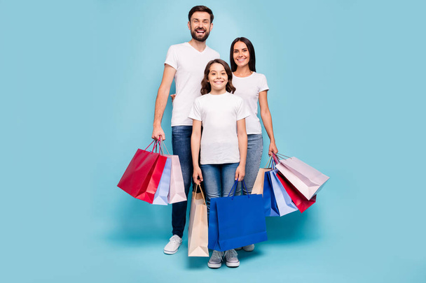 Full length photo of three people mom mommy dad daddy schoolkid shop retail on black friday wear white t-shirt denim jeans sneakers isolated over blue color background - Foto, Imagem